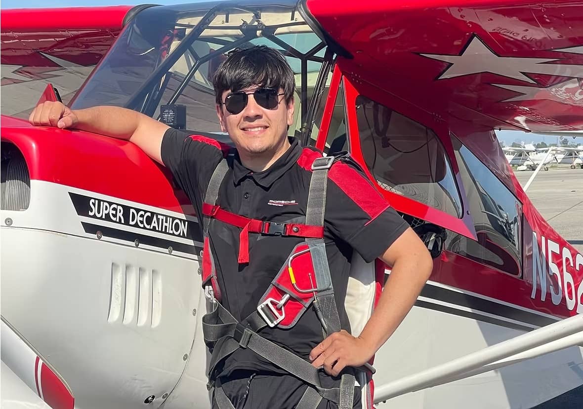 Dylan Gomez, Gomez Aviation flight instructor, beside a Super Decathlon on the ramp at Long Beach Airport (KLGB)